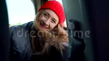 阳光明媚的一天，幸福的年轻女子坐在副驾驶座上看着窗外